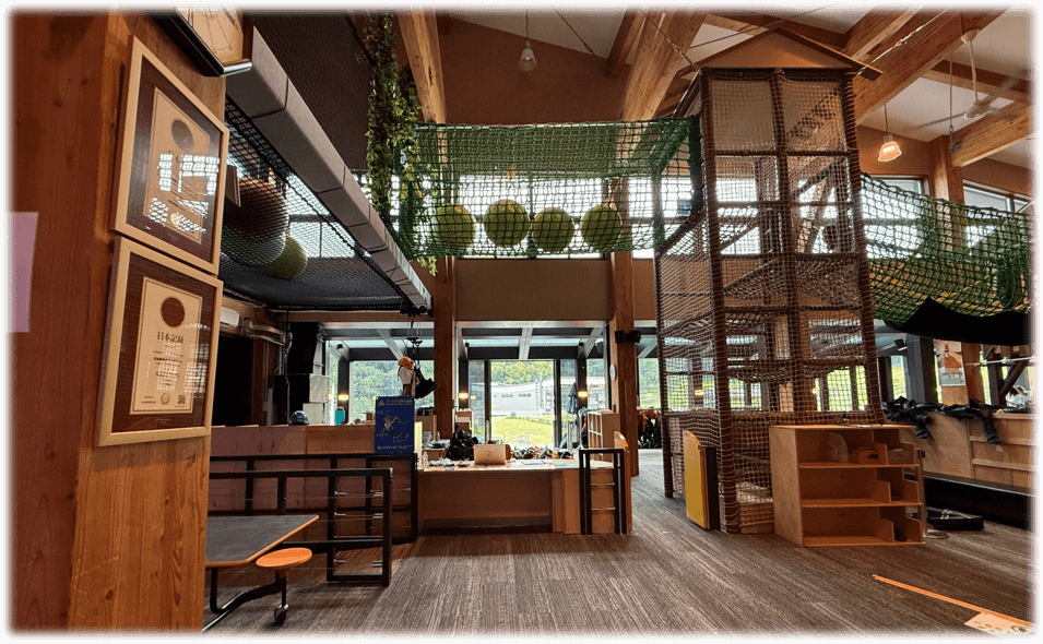 HANAZONO308 内観。上は子供が遊べる施設の一部。正面はHANAZONO ZIPFLIGHTの受付と器具を装着する場所。
左側には、日本一長いジップラインを証明する額縁がある。