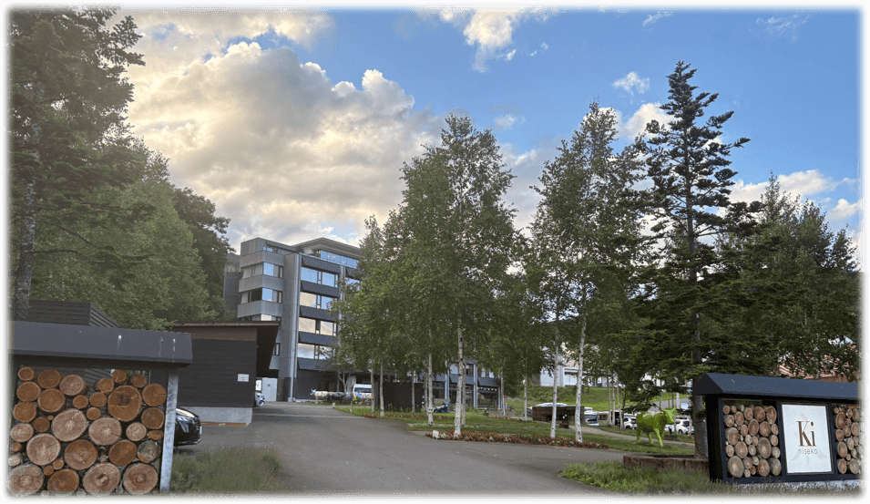 木ニセコ外観。木で装飾された門。白樺が立ち並び、奥にホテルが見える。